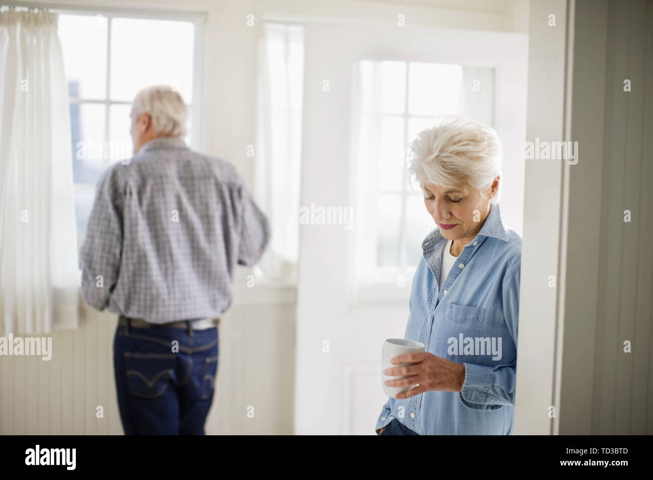 Reifen erwachsenen Paar stehend mit einem Drink in einem Raum. Stockfoto