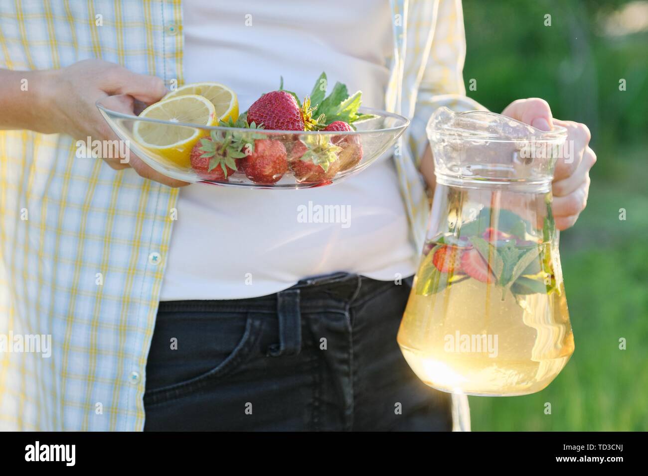 Frühling Sommer Erfrischungen, Frau in Natur Holding jar der Erdbeere Minze und Zitrone. Stockfoto