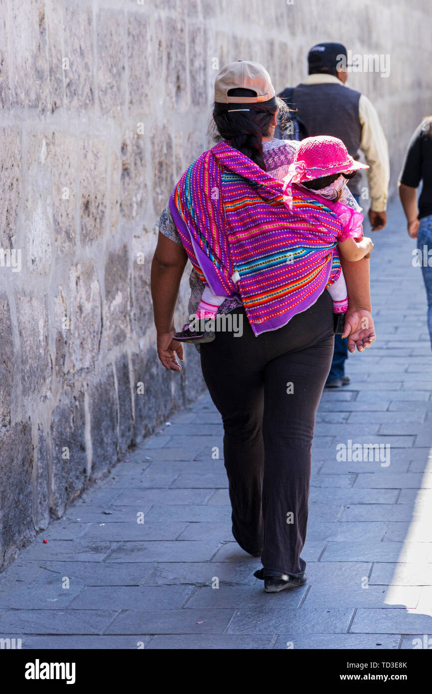 Frau, die ein Baby in einen Schal auf ihr zurück in Arequipa, Peru, Südamerika gewickelt Stockfoto