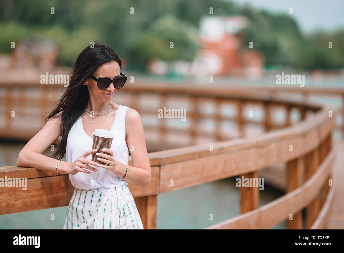 Frau geht mit Kaffee im Freien in der Stadt Stockfoto