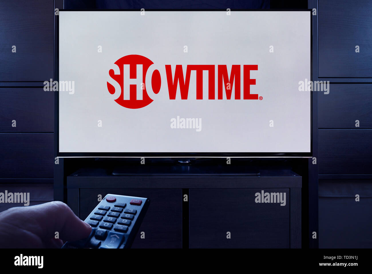 Ein Mann Punkte eine TV-Fernbedienung auf den Fernseher, die zeigt das Logo für den Showtime on demand Video Streaming Service (nur redaktionelle Nutzung). Stockfoto