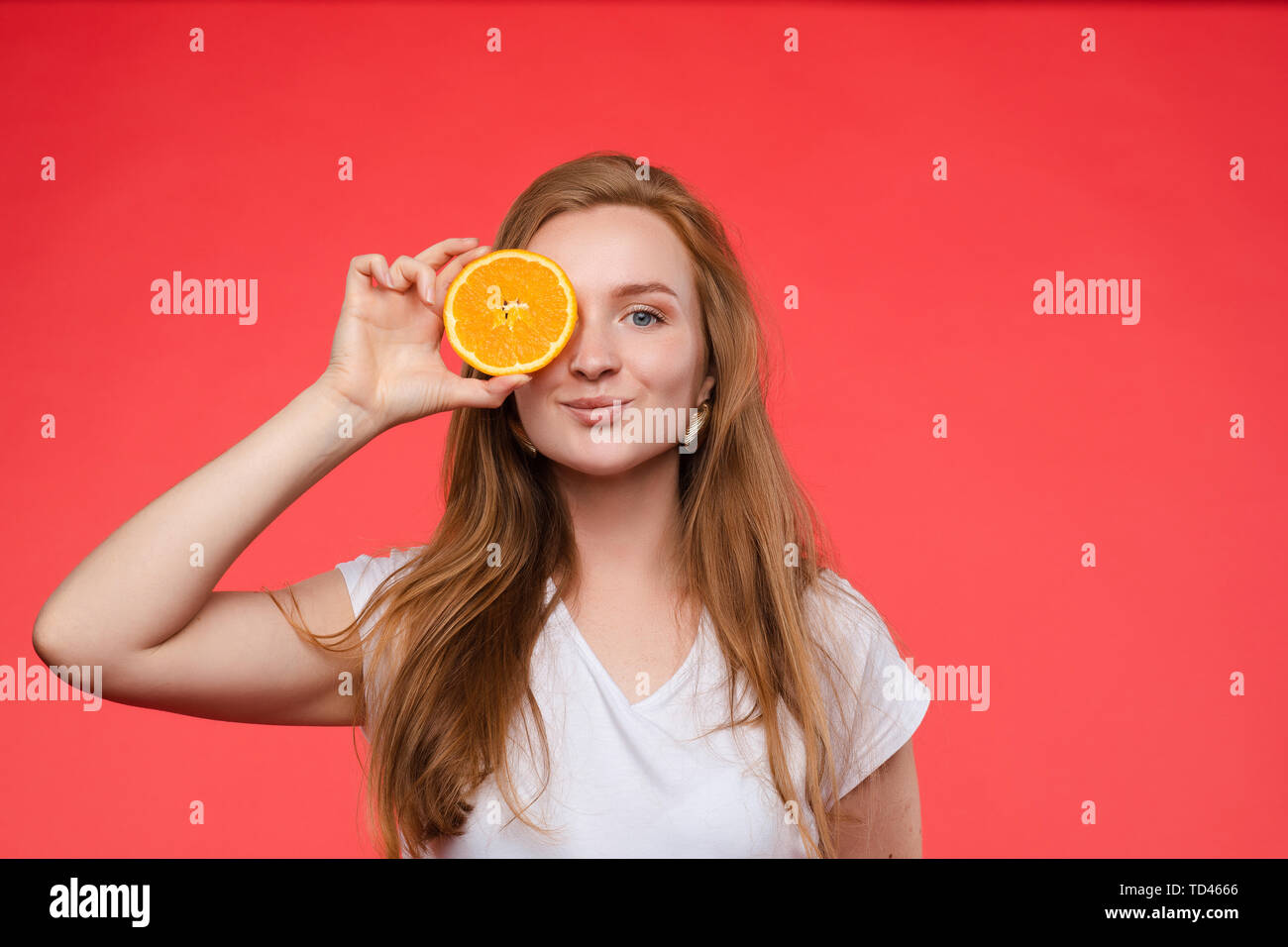 Lustige modische Mädchen mit Frisur holding Orangen auf die Augen. Stockfoto