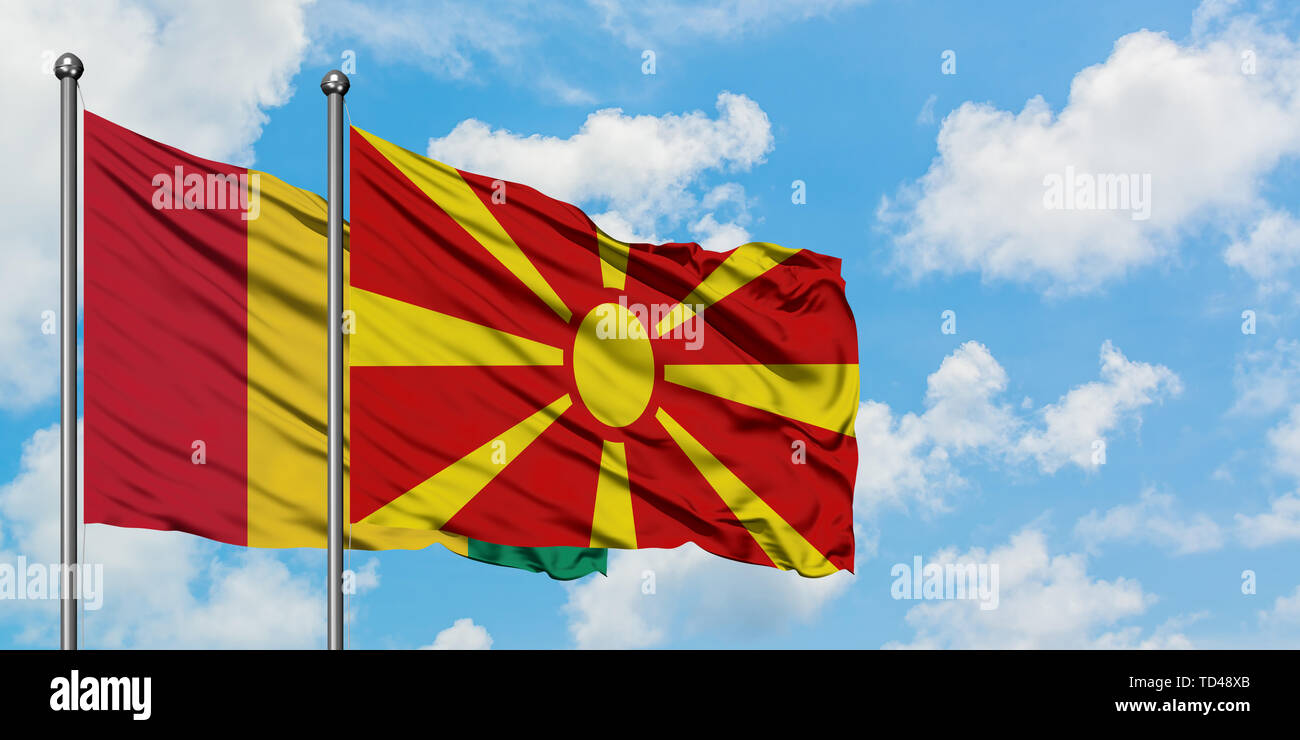 Guinea und Mazedonien Flagge im Wind gegen Weiße bewölkt blauer Himmel zusammen. Diplomatie Konzept, internationale Beziehungen. Stockfoto