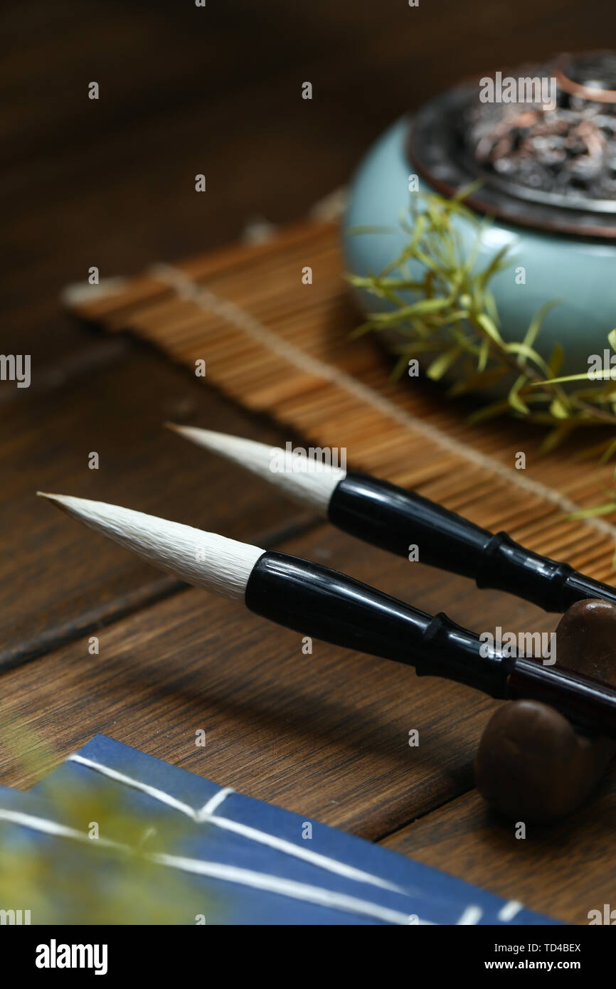 Chinesische Schrift Bürsten, Vintage altes Buch, Räuchergefäß auf hölzernen Tisch Stockfoto