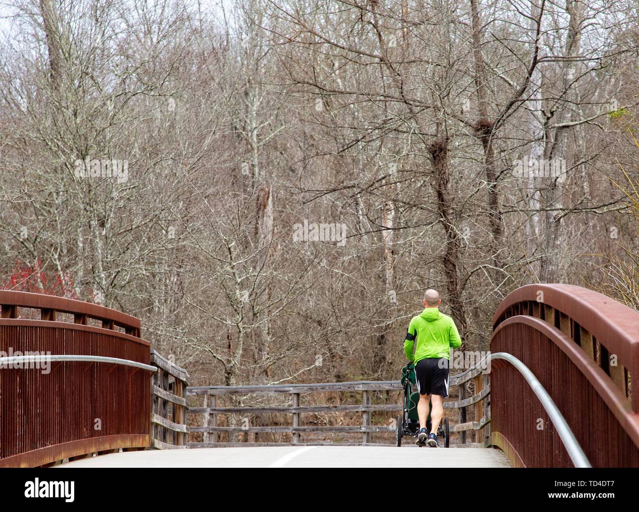 Vater schieben Kinderwagen über die Brücke Stockfoto