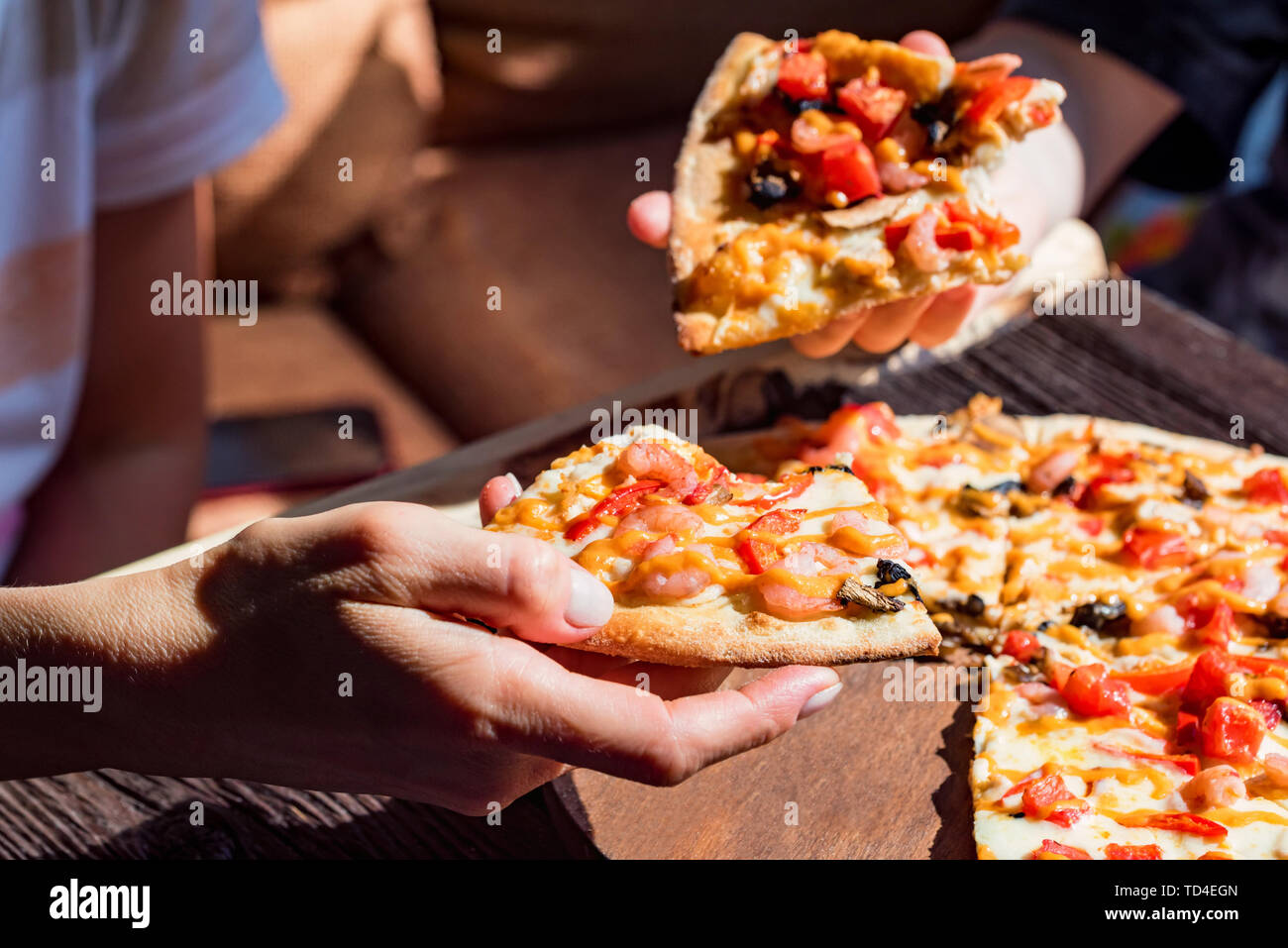 Woman&amp;#39;s Hand, denn Scheiben frische Pizza mit Krabben und Champignons ...