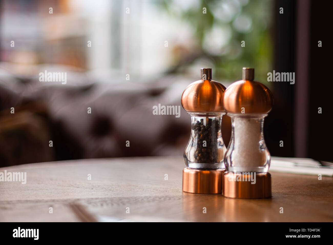 Eine Bronze- Salz- und Pfefferstreuer und Schleifer sitzen auf einem Tisch in einem irischen Restaurant Stockfoto