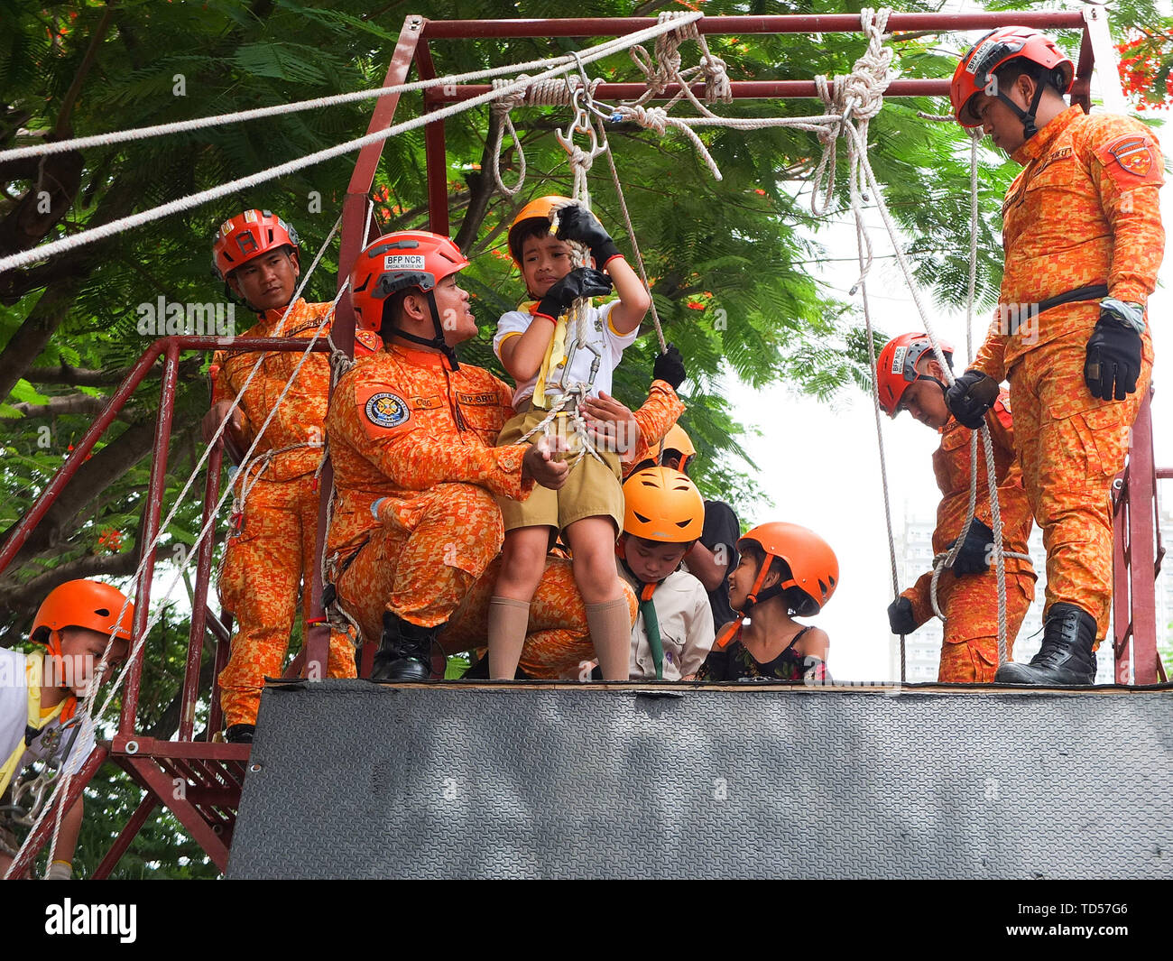 Manila, Philippinen. 1 Jan, 2012. Ein Knabe, Angst vor Höhen, die von einem Mitglied des Präsidiums des Brandschutzes während der Feierlichkeiten getröstet wird. Die Philippinen die 121. Tag der Unabhängigkeit mit gefeiert: Spiele für die Kinder und Jugendlichen, indem sie Leben Sicherheit Demonstrationen und eine Ausstellung von militärischer Hardware und Waffen, die von den speziellen Armee Kräfte im Luneta Park in Manila verwendet. Credit: Josefiel Rivera/SOPA Images/ZUMA Draht/Alamy leben Nachrichten Stockfoto