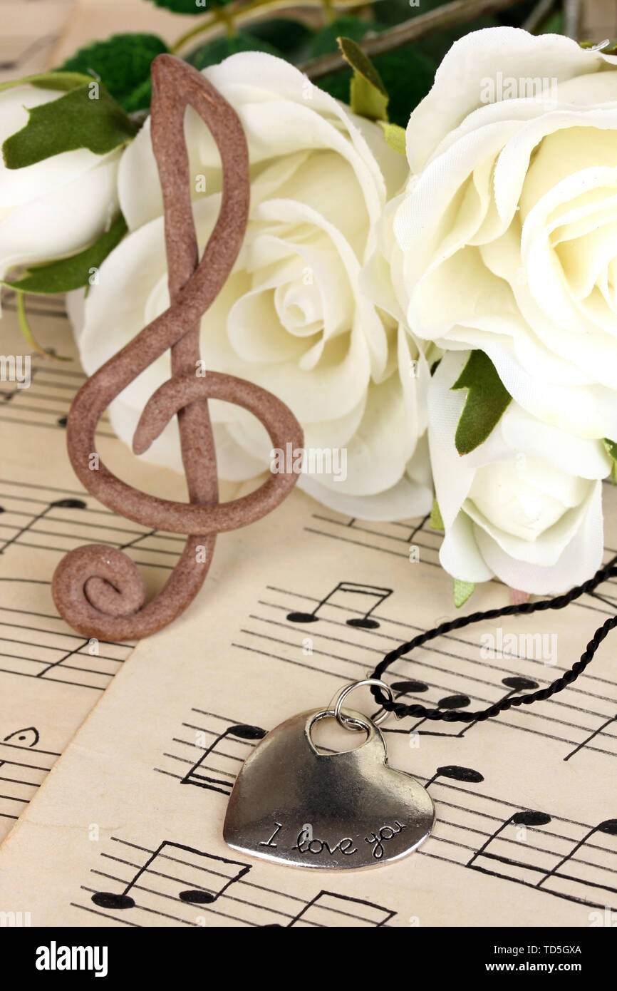 Violinschlüssel, Anhänger und Rosen auf musikalischen Hintergrund Stockfoto