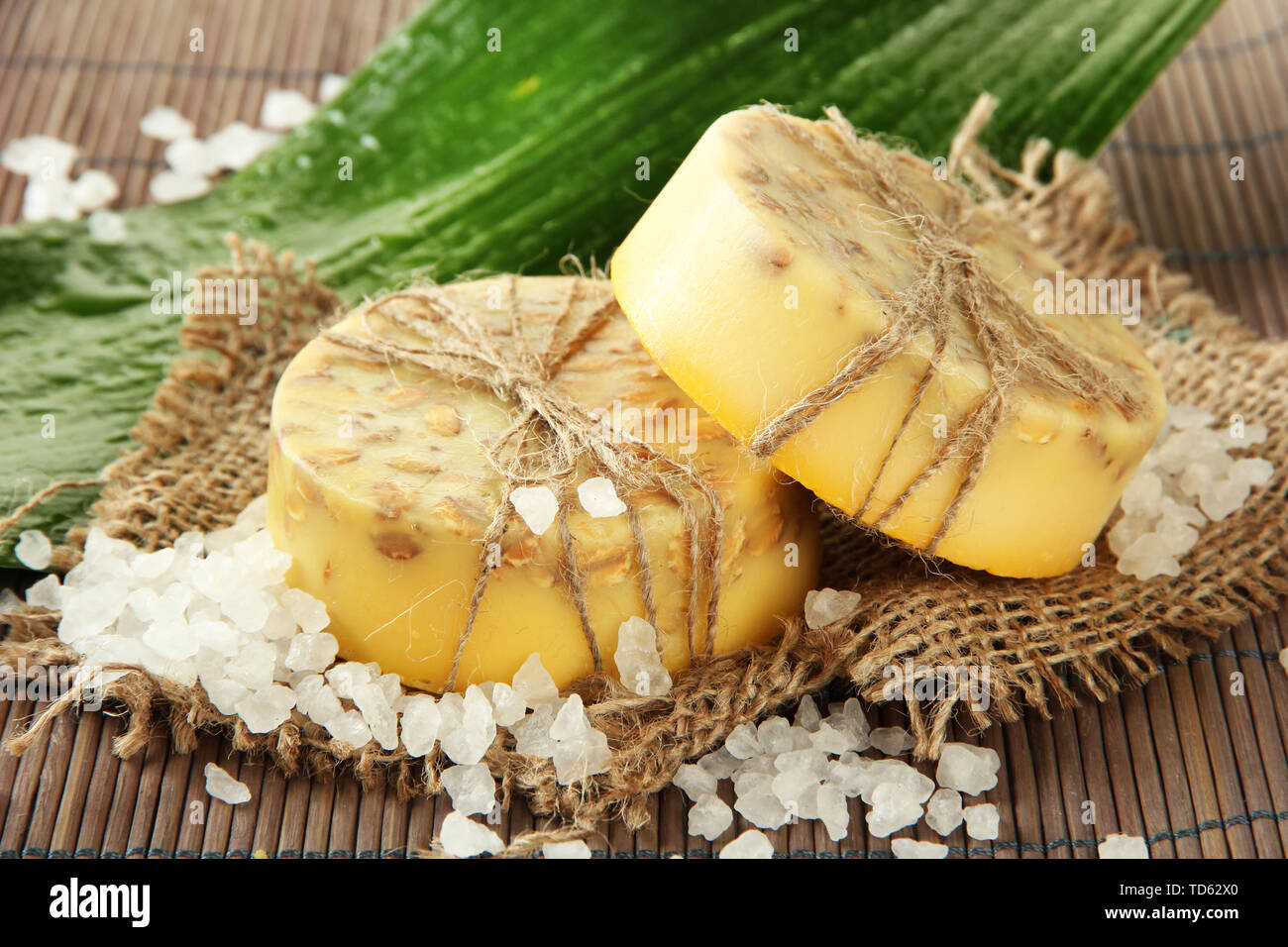 Handgemachte Seife, Meersalz und Blatt auf grau Bambus Matte Stockfoto