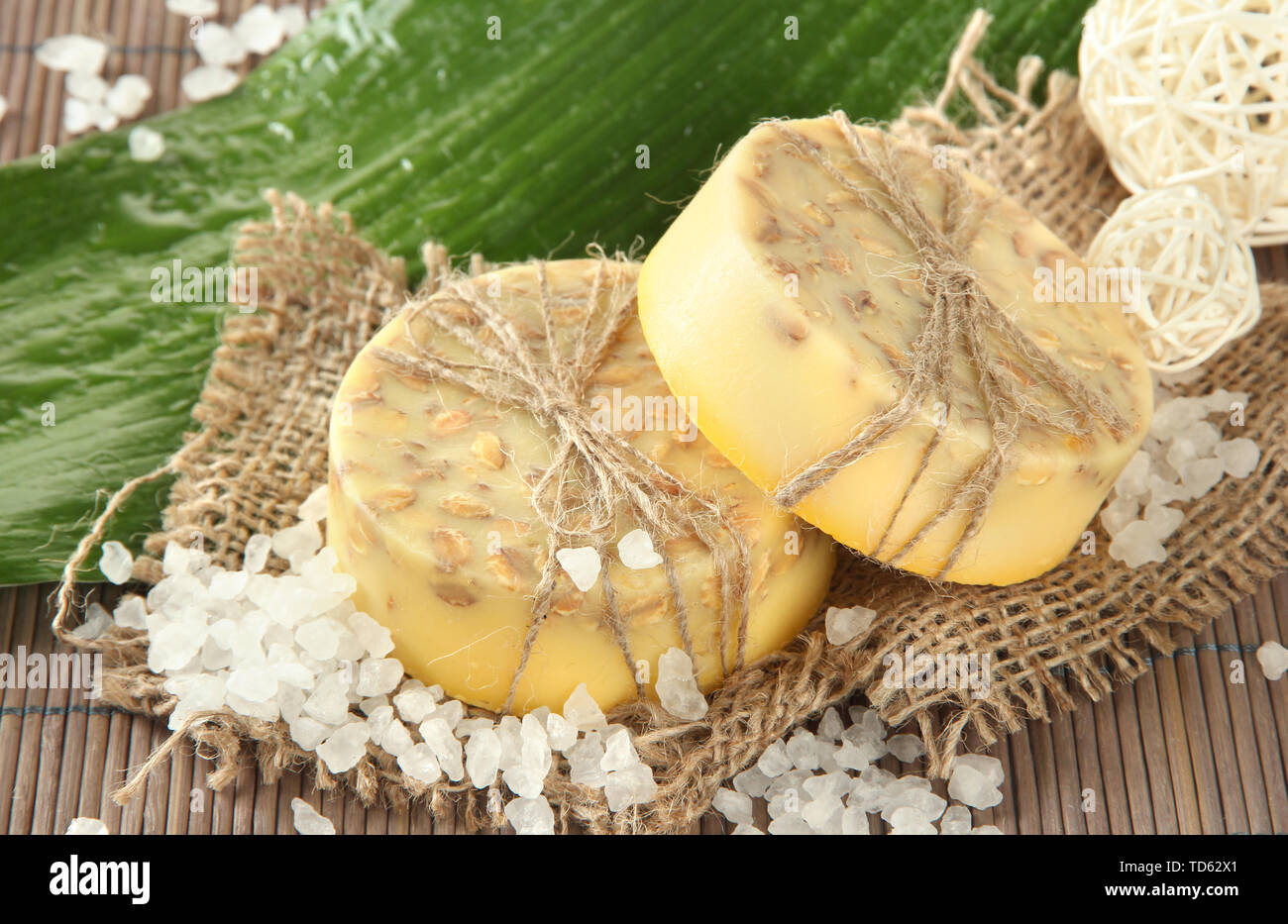 Handgemachte Seife, Meersalz und Blatt auf grau Bambus Matte Stockfoto