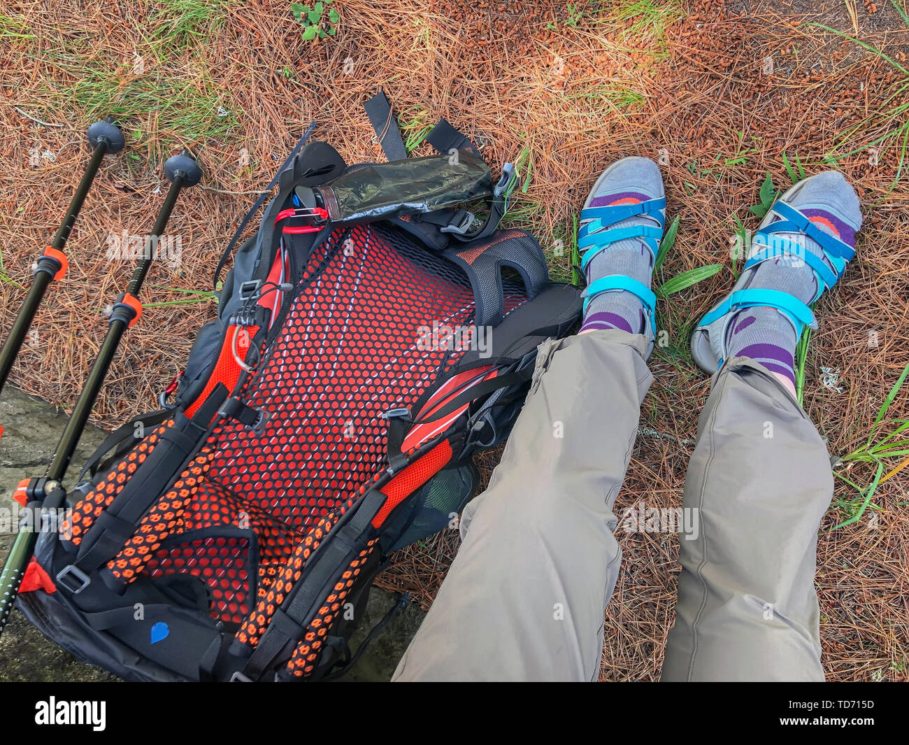Beine, Rucksack und Trekking Stöcke, Wanderstöcke im Hintergrund. Aktiven und gesunden Lebensstil im Sommer Stockfoto