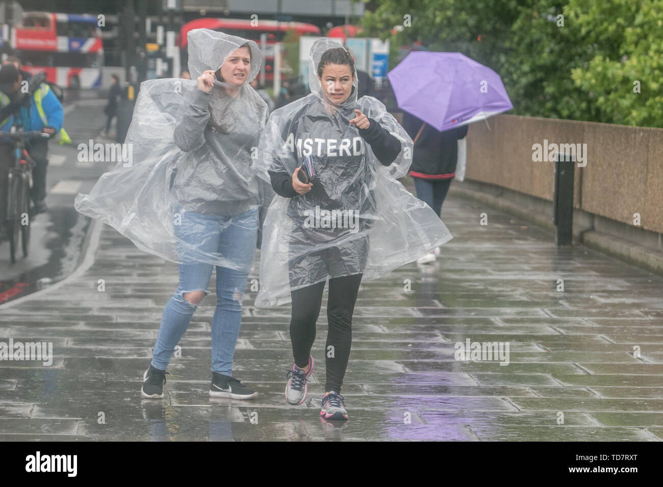 London, Großbritannien. 13. Juni, 2019. Ein Fußgänger tragen Ponchos Regen während einer sintflutartigen Regenfällen während der Überquerung der Westminster Bridge in London. Credit: Amer Ghazzal/SOPA Images/ZUMA Draht/Alamy leben Nachrichten Stockfoto