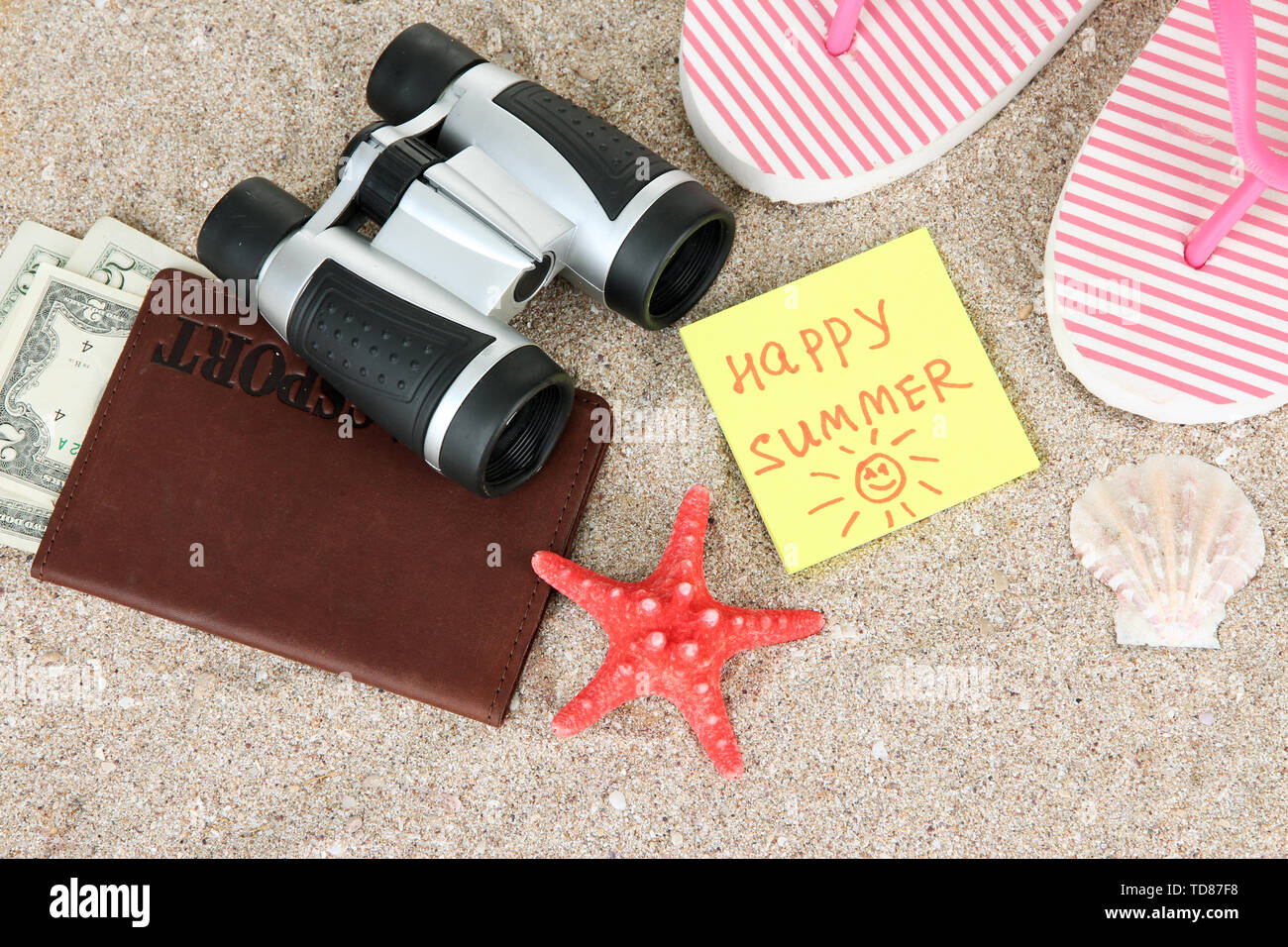 Zusammensetzung mit Flip-flops, Fernglas, Notizblock und Geld, auf Sand Hintergrund Stockfoto