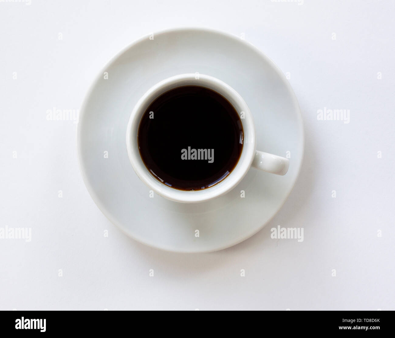 Tasse Espresso mit Untertasse auf weißem Hintergrund. Ansicht von oben. Schließen Sie herauf Bild. Stockfoto