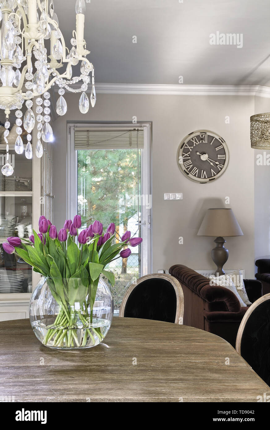 Rosa Tulpen in großen klares Glas Vase auf hölzernen Esstisch im großen Speisesaal des VEREINIGTEN KÖNIGREICHS UND IRLANDS NUR RECHTE Stockfoto