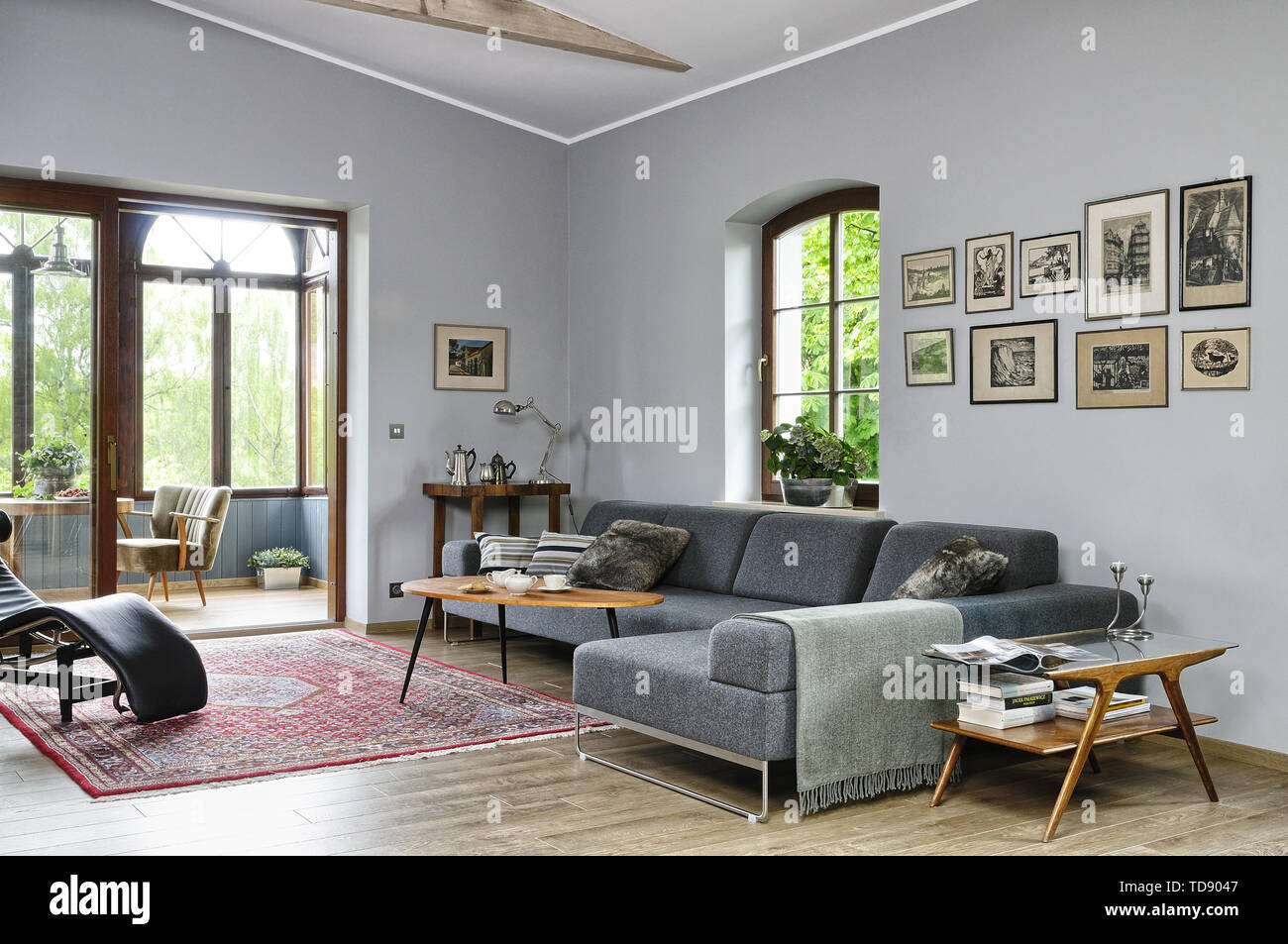 Tisch vor Grauen Sofa in ein geräumiges Wohnzimmer mit Blick auf den Wintergarten, VK und Irland NUR VERWENDEN Stockfoto