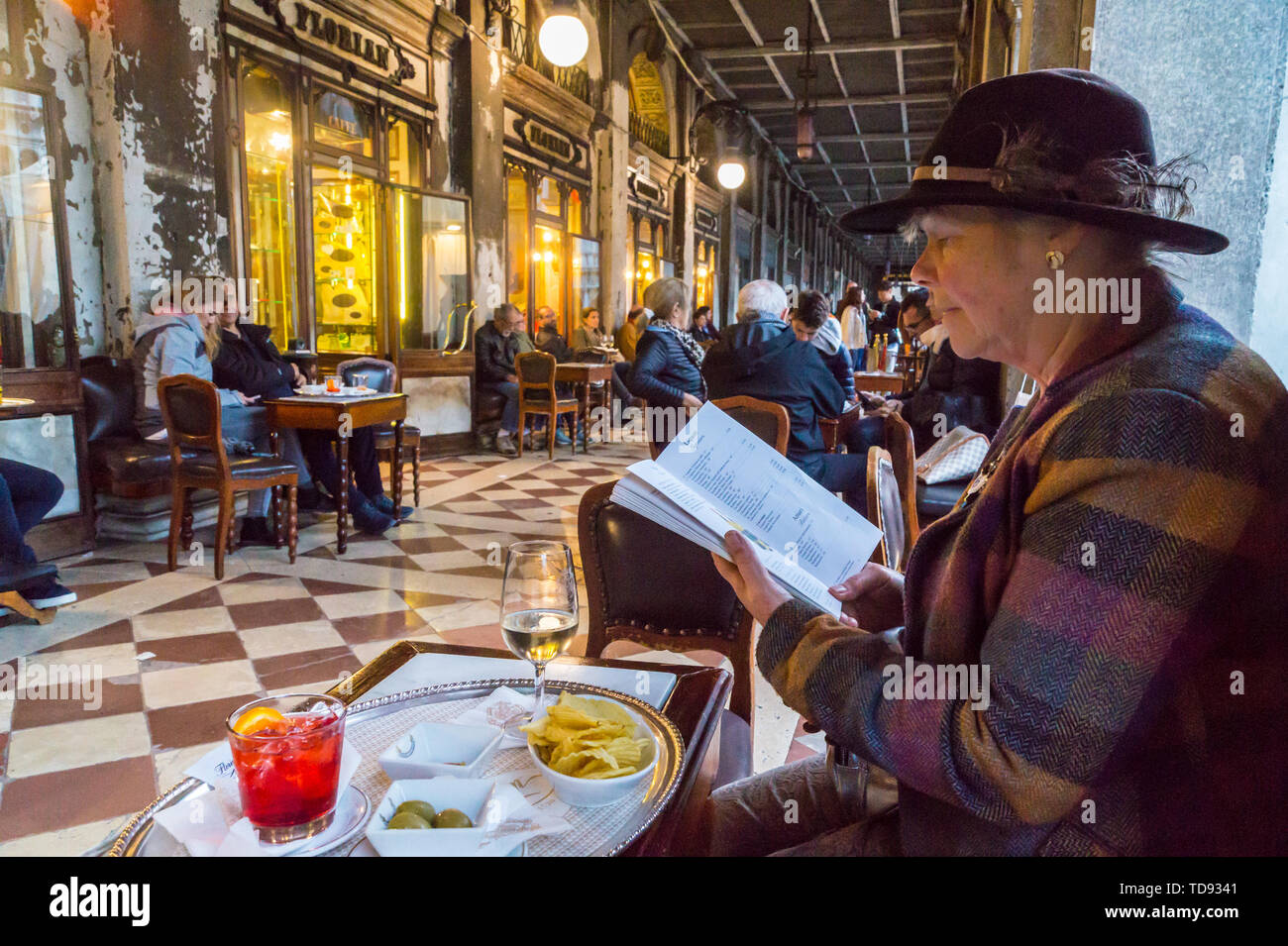 Eine Frau an der Speisekarte Caffè Florian, St. Mark's Square, San Marco, Venedig, Venetien, Italien Suche Stockfoto