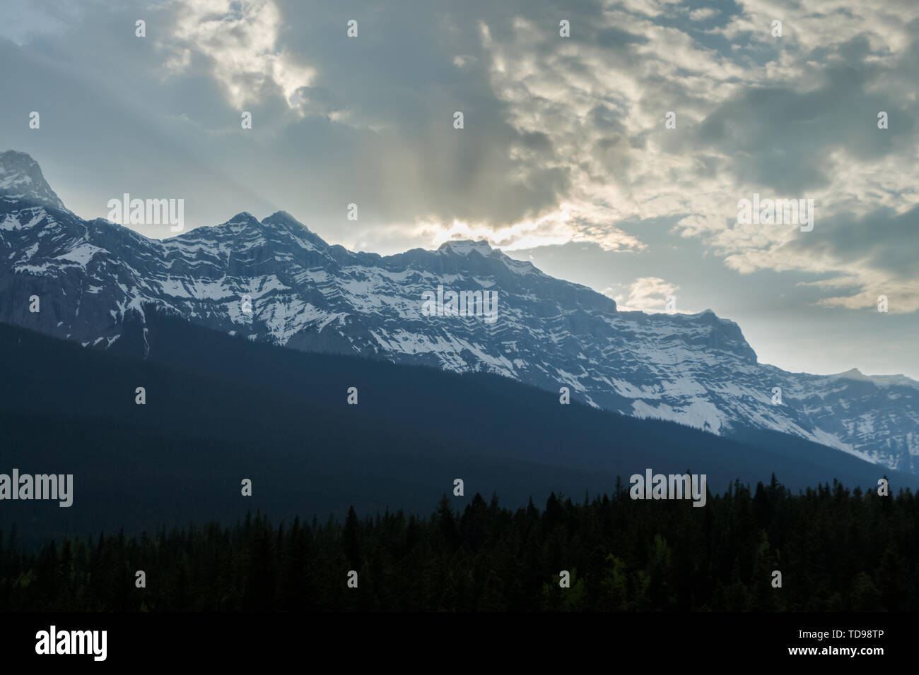 Sonne bricht durch die Wolken über den Bergen in der Dämmerung Stockfoto