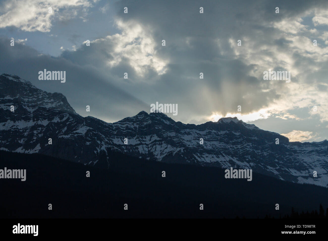 Sonne bricht durch die Wolken über den Bergen in der Dämmerung Stockfoto