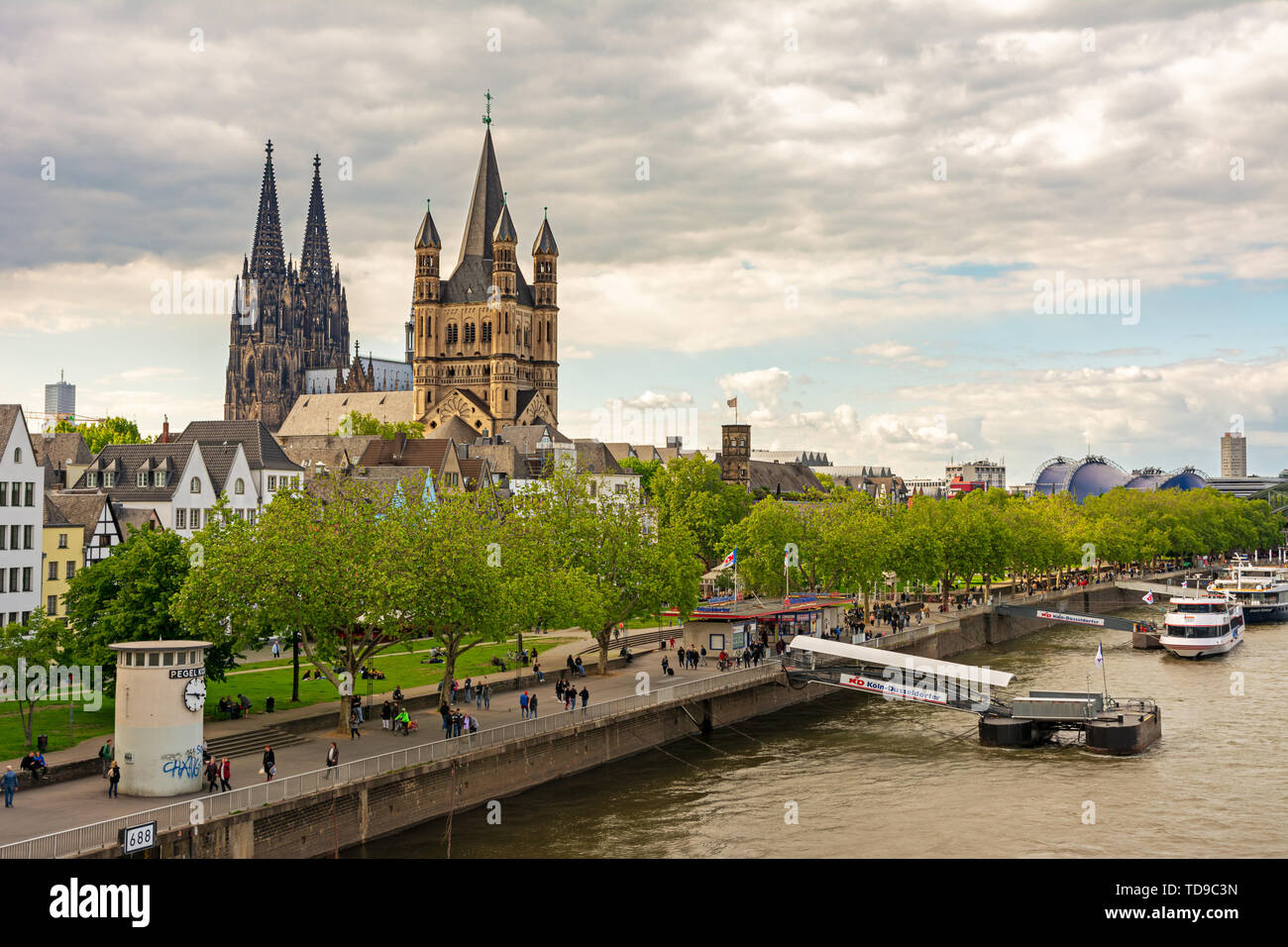 Köln, Deutschland - 12. Mai: Touristen am Rhein in Köln, Deutschland, am 12. Mai 2019. Blick auf den Kölner Dom und große Sain Martin Kirche. Stockfoto