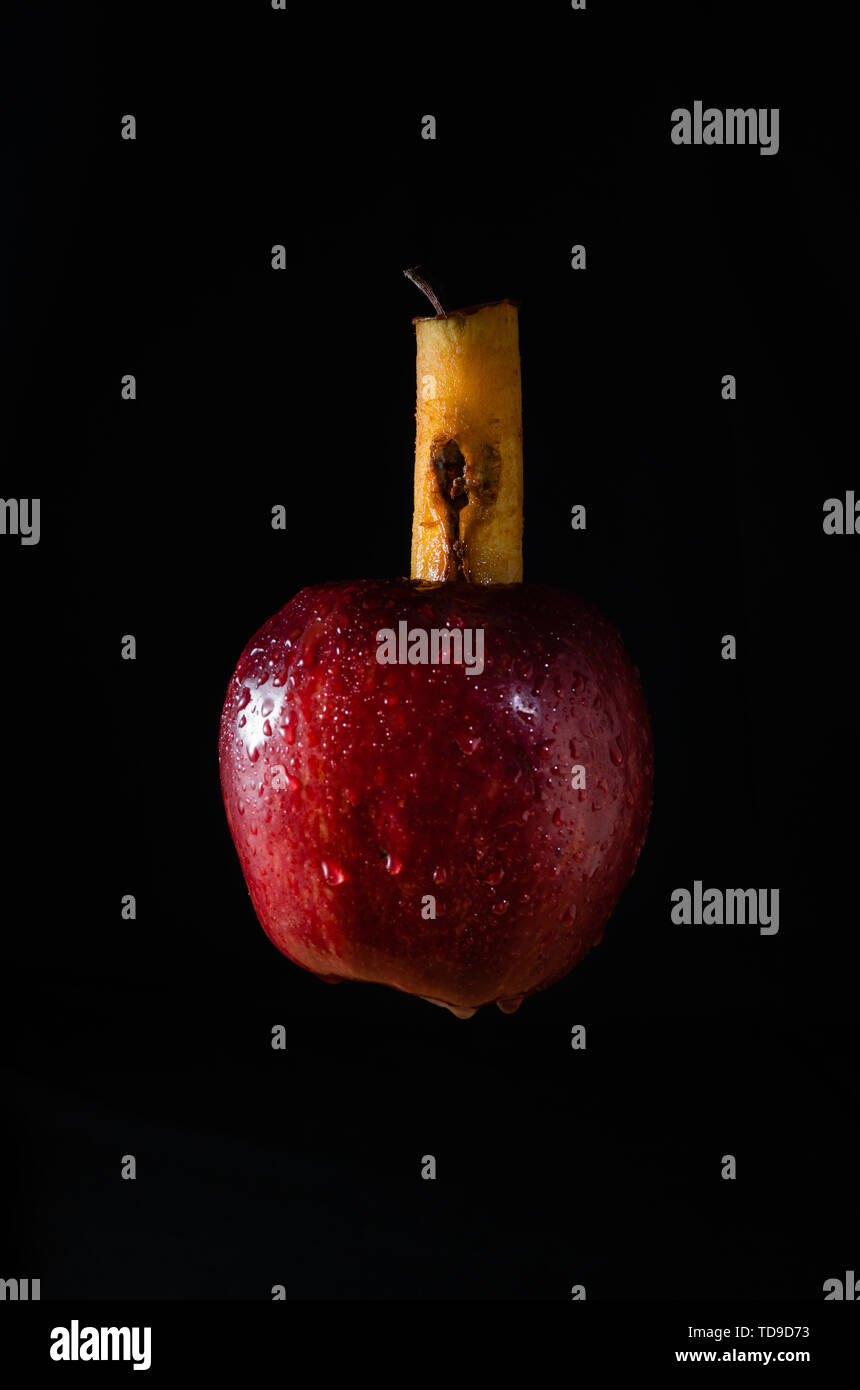Red Apple mit kranken Herzen schweben in die schwarze Leere Stockfoto