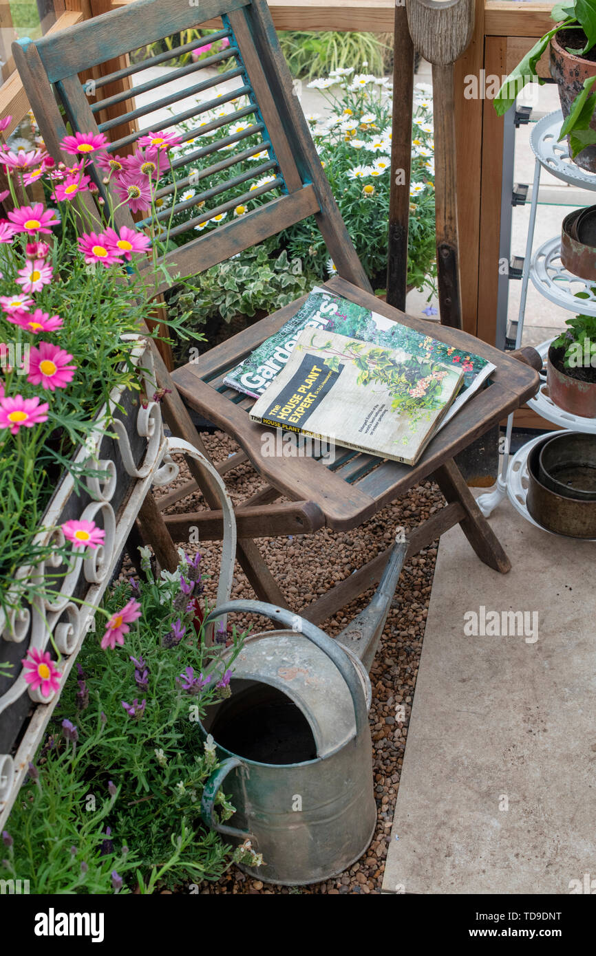 Holzstuhl in einem Gewächshaus eine Blume zeigen. Großbritannien Stockfoto