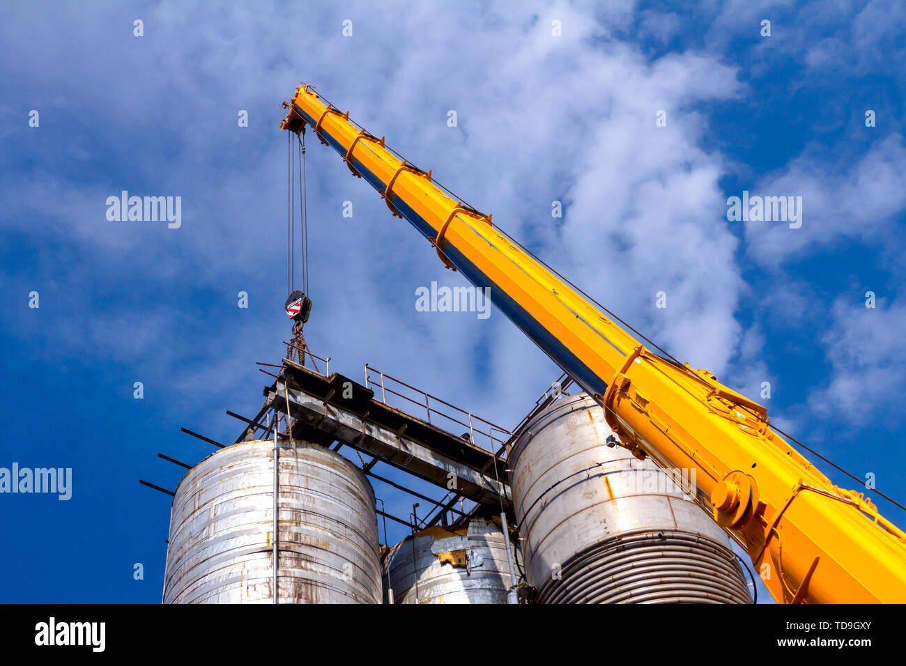 Kran ist und hält die Balance mit heavy metal Silo in industriellen Komplexes. Stockfoto