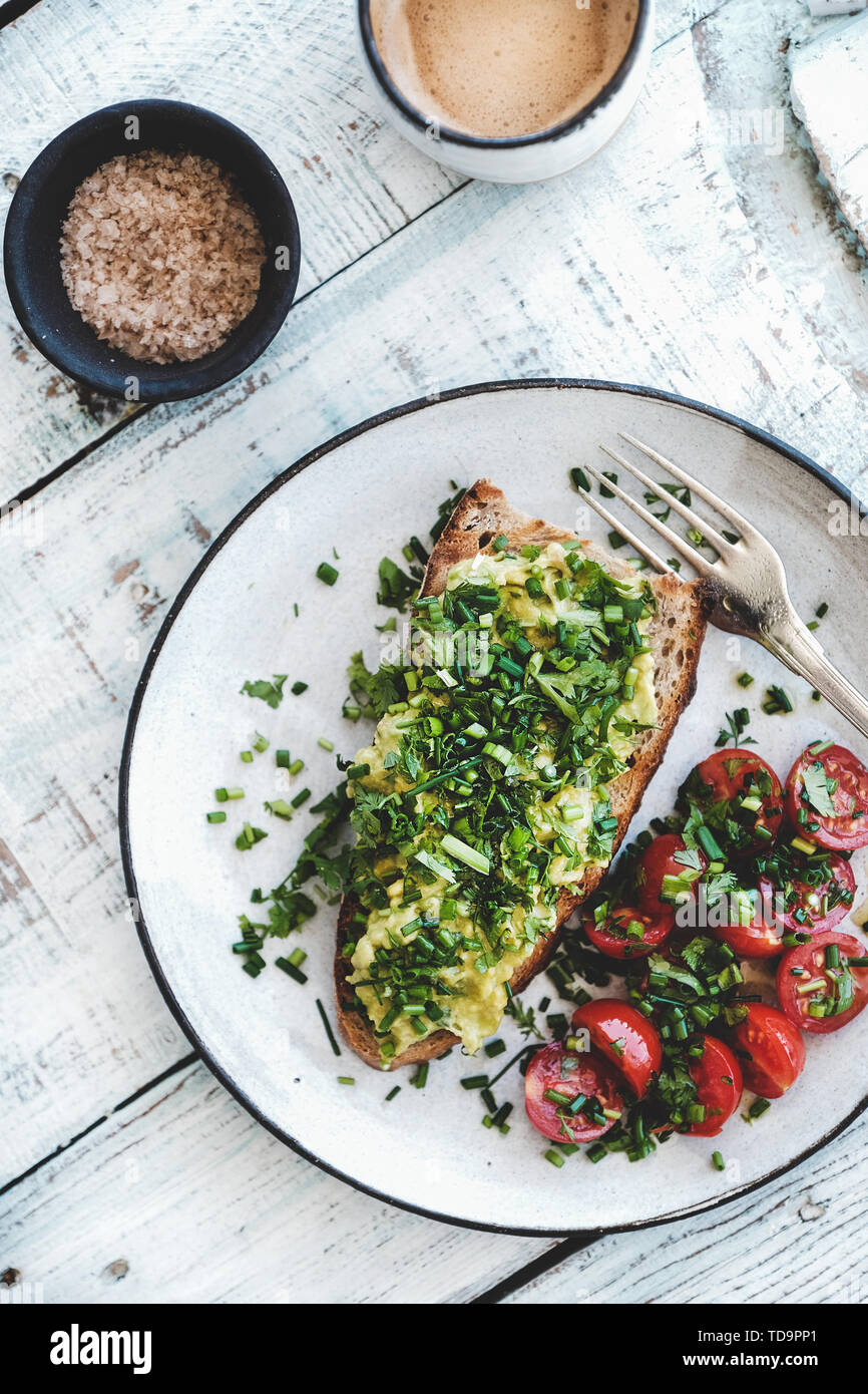 Vegane Mahlzeit mit Avocado Toast und Kaffee im Becher Stockfoto