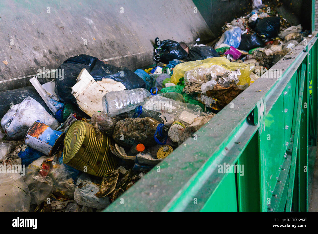 Abfallbehälter auf die Sortieranlage einer Recyclinganlage. Der Prozess der Müll trennen in einen Container. Pakete, Bügeleisen Dosen und Kunststoffflaschen Stockfoto