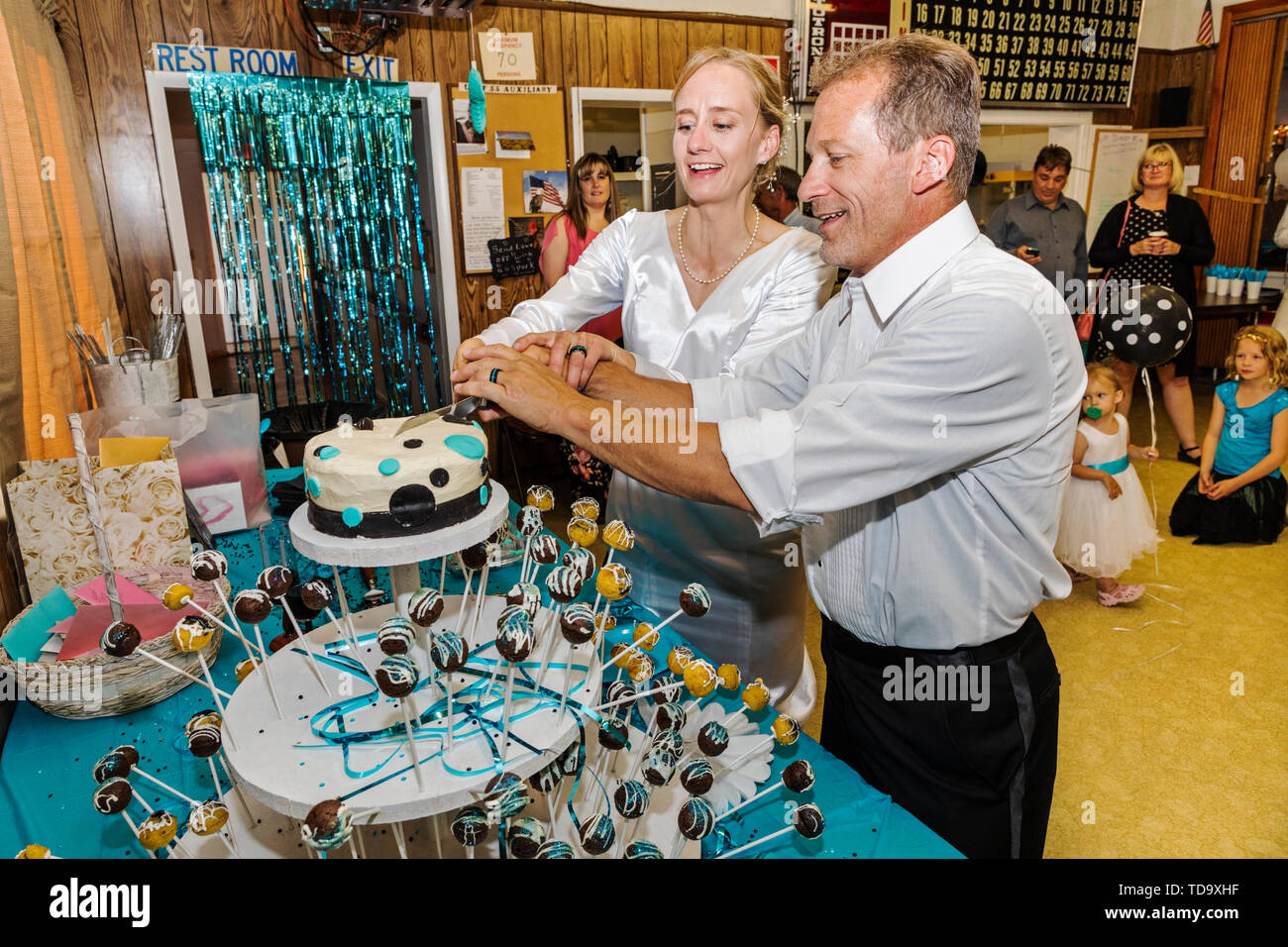 Braut & Bräutigam schneiden Sie den Kuchen auf der Hochzeitsfeier; Kongress Kirche; Buena Vista; Colorado; USA Stockfoto