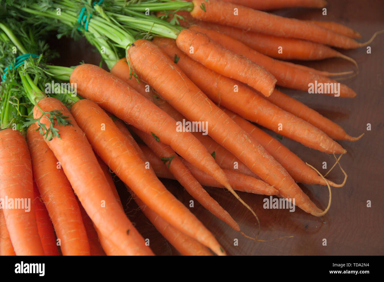 Ein Haufen von Möhren auf einem hölzernen Tisch besetzen alle Raum des Bildes Stockfoto