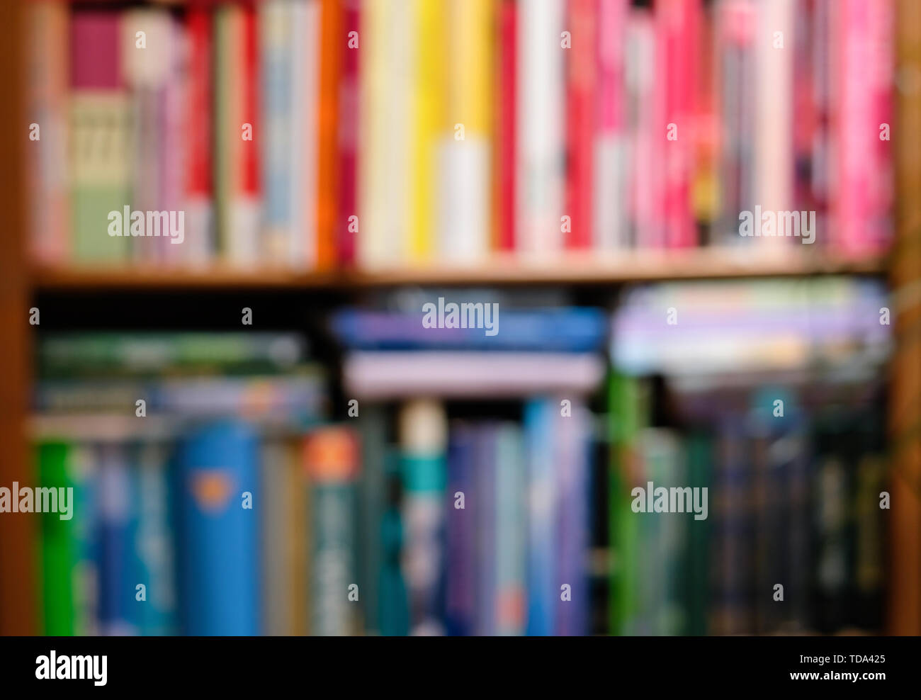 Abstrakte verschwommen Bücherregal mit bunten hellen Bücher. Bildungs- und Innenraumkonzept. Stockfoto