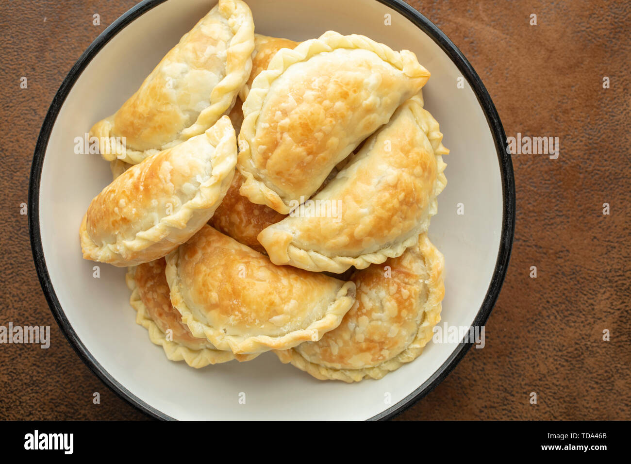 Golden gebackene argentinische Fleisch Empanadas gerade gemacht und in eine Schüssel gelegt Stockfoto