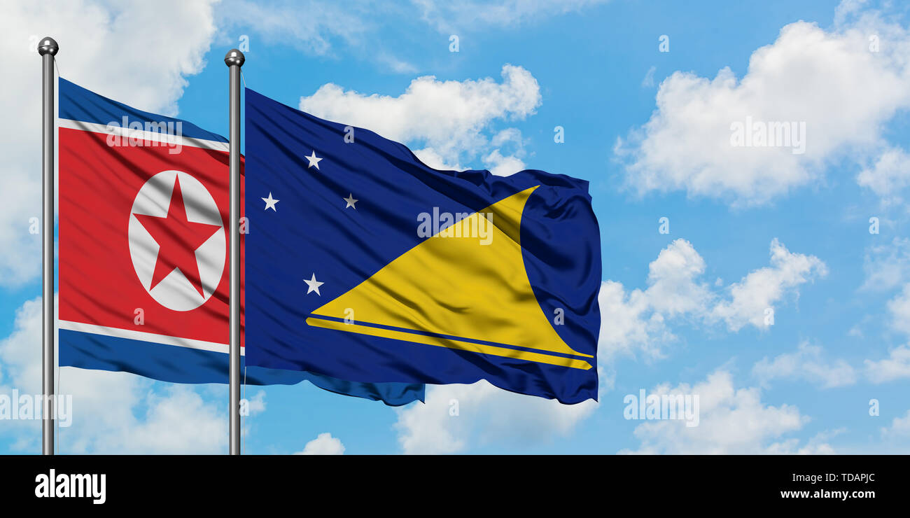 Nordkorea und Tokelau flag waving im Wind gegen Weiße bewölkt blauer Himmel zusammen. Diplomatie Konzept, internationale Beziehungen. Stockfoto