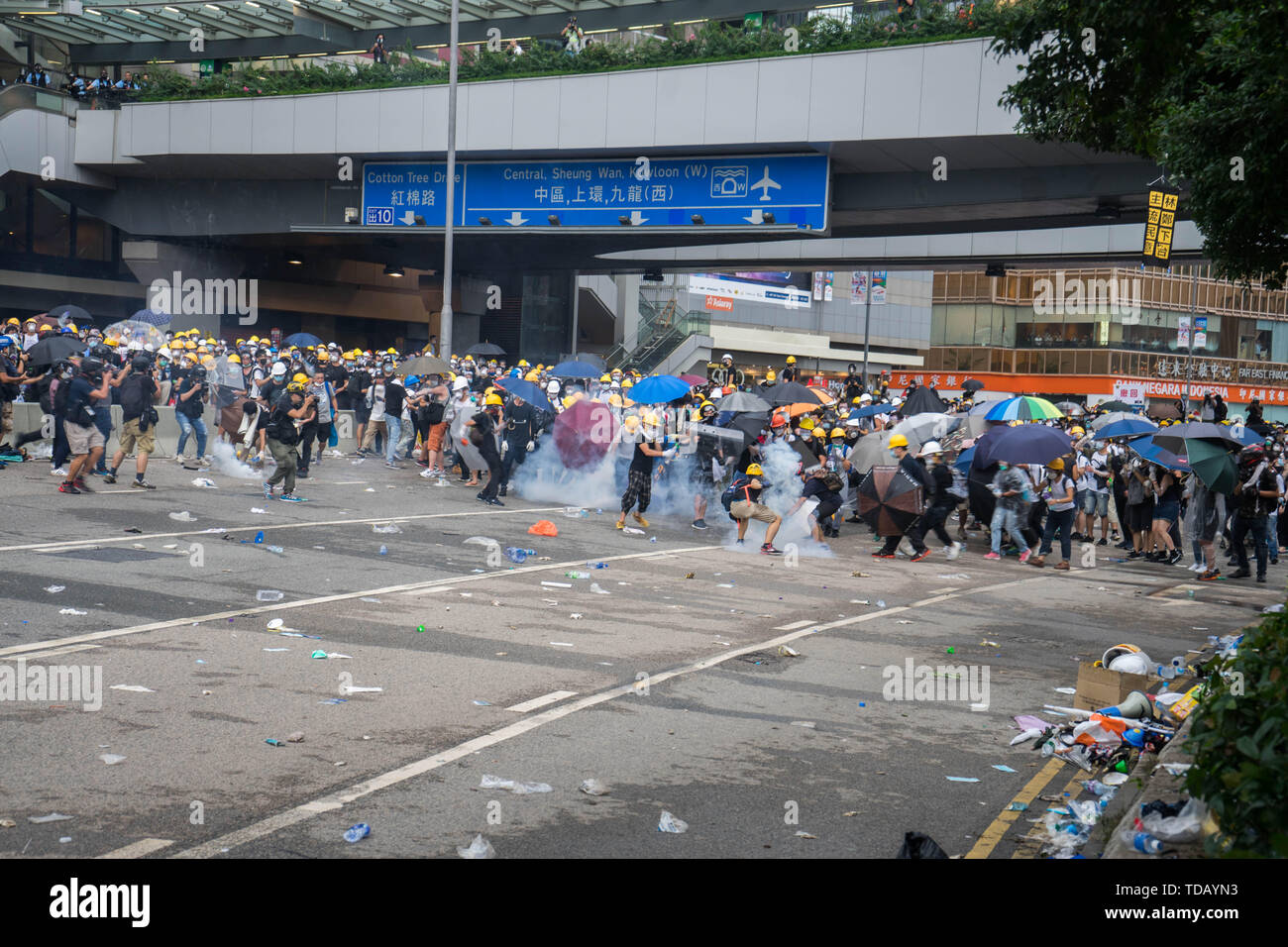 Die demonstranten Rush bis zu den Dosen Tränengas durch die Polizei, wie sie in der Nähe von ihnen landeten. Tausende von Demonstranten besetzten die Strassen in der Nähe des Gesetzgebenden Rates Komplex in Hongkong Regierung zu verlangen Auslieferung Gesetzentwurf zurückzuziehen. Die Regierung von Hongkong hat sich geweigert zu entziehen Verzögerung mit der Rechnung, nachdem Hunderttausende von Menschen gegen ihn am Sonntag marschierten oder. Stockfoto