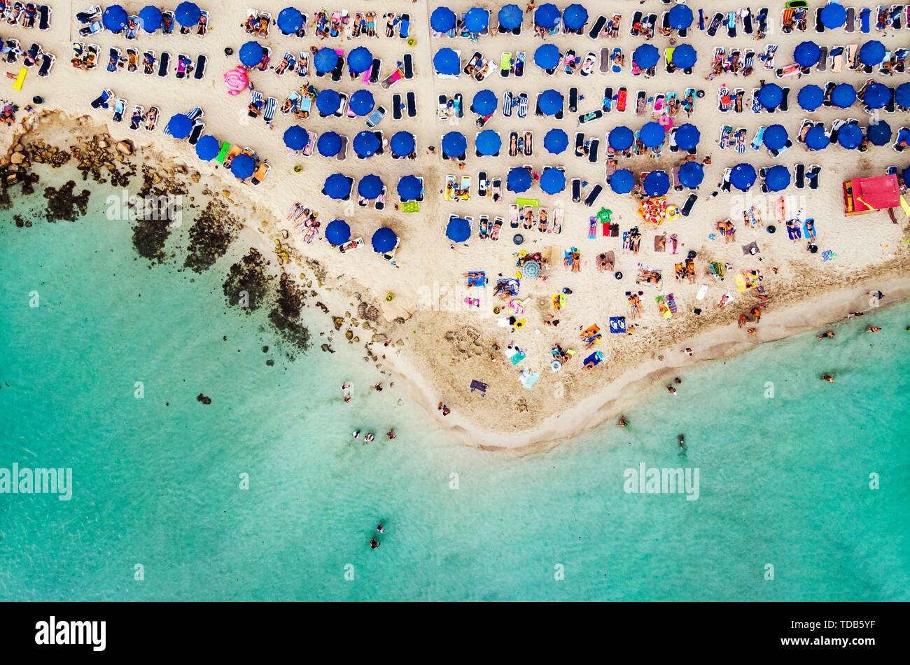 Erstaunlich Luftbild von oben über Nissi Beach in Zypern. Nissi Strand bei Flut. Touristen am Strand entspannen. Überfüllten Strand mit vielen Touristen Stockfoto