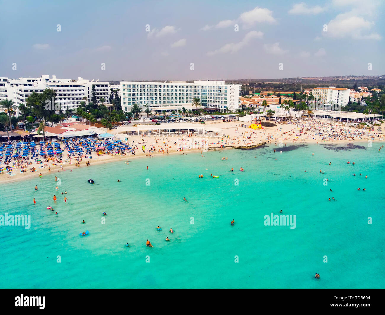 Buntes Bild von Strand von Ayia Napa mit einigen der Resorts und Stroh Sonnenschirm Sonnenschirme Stockfoto