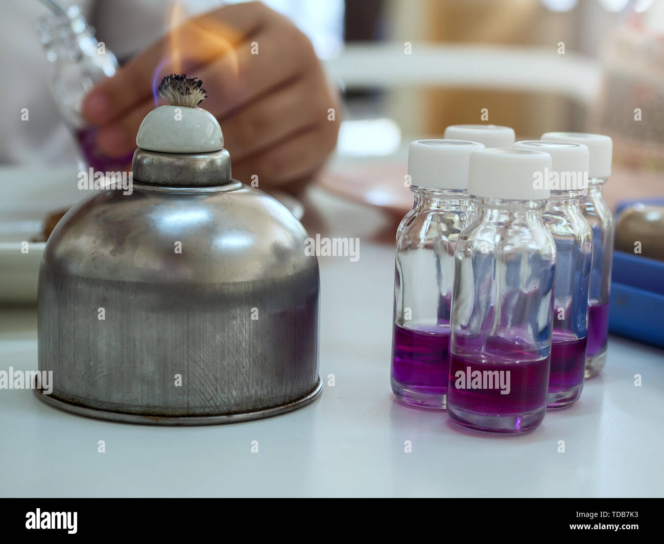 In der Nähe der Flasche mit einem Spiritus brenner sterilisiert werden vor der Verwendung in Bakterienkulturen. Medizin und Mikrobiologie Konzept. Stockfoto