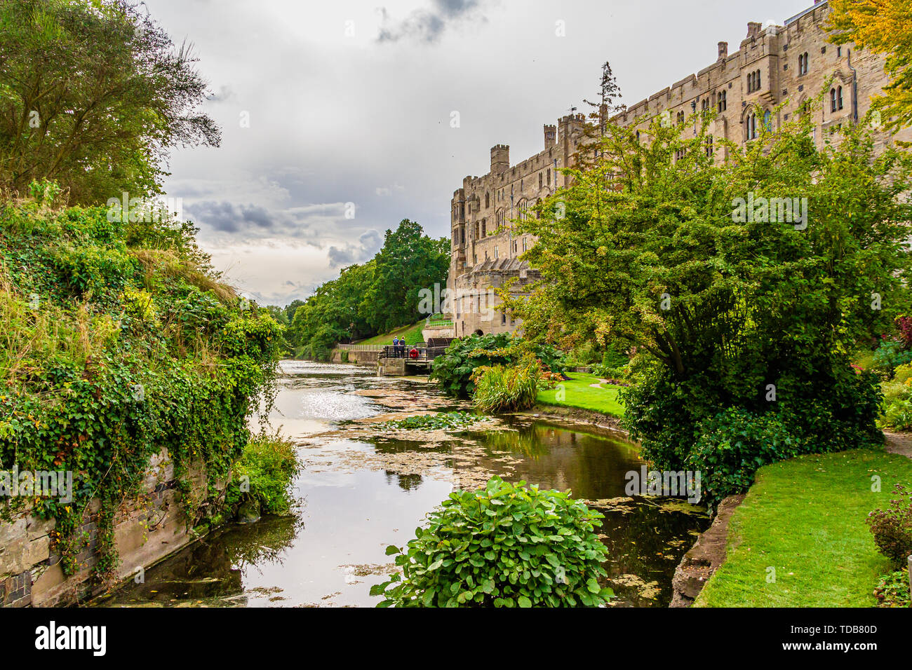 Fluss Avon aus alten Burg Brücke, gegenüber der Mühle und Süden Warwick Castle's Fassade. Warwick, Großbritannien. Sommer 2018. Stockfoto