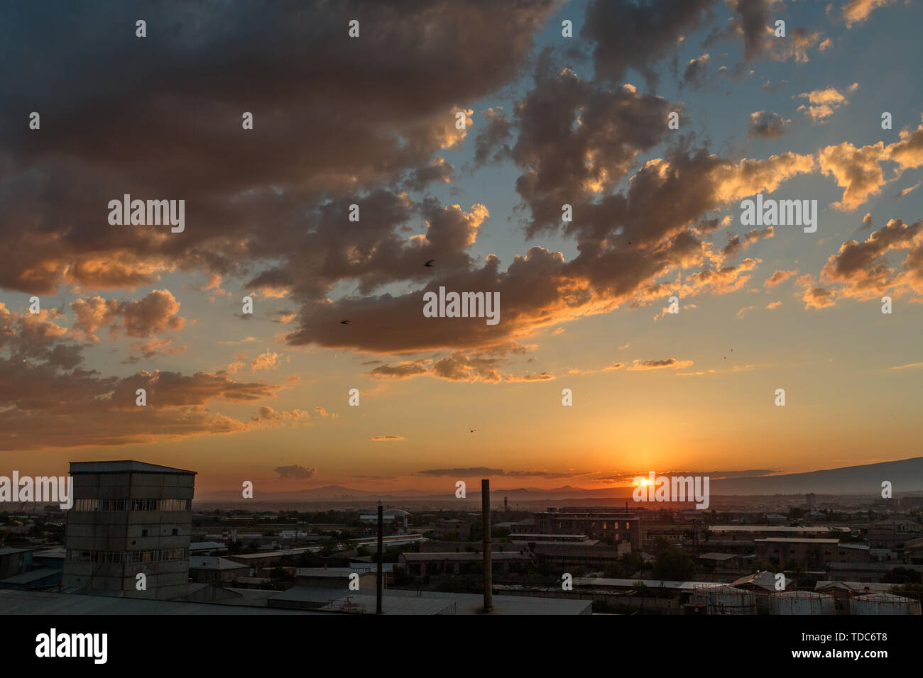 Foto der Sonnenuntergang und Wolken sowie die Infrastruktur der kleinen Stadt Stockfoto