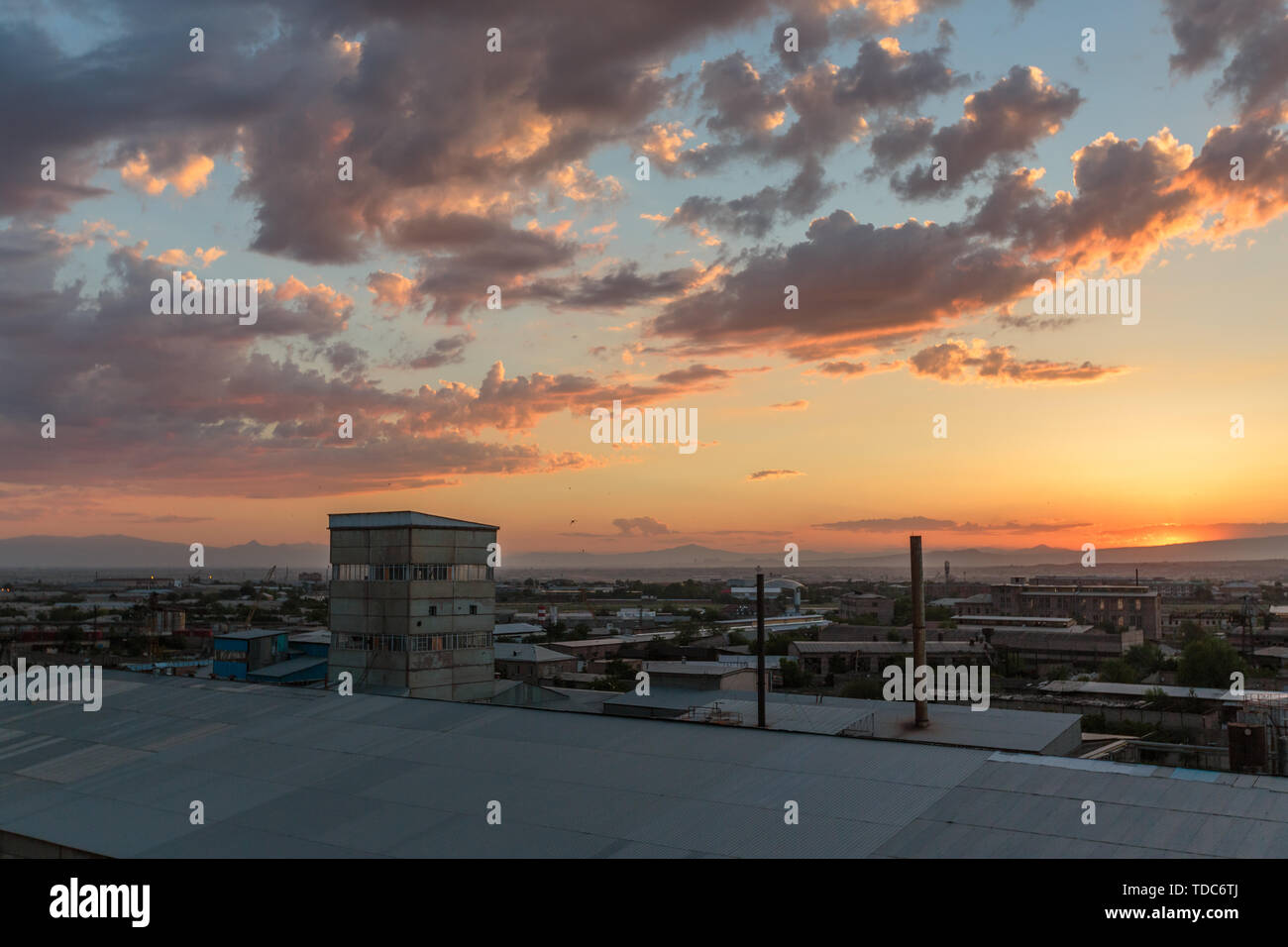 Foto der Sonnenuntergang und Wolken sowie die Infrastruktur der kleinen Stadt Stockfoto