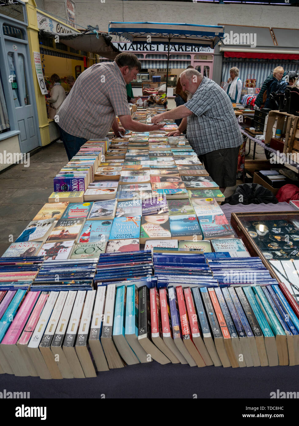 Käufer suchen auf gebrauchten Buch in Abergavenny Indoor Halle Wales UK Abschaltdruck Stockfoto