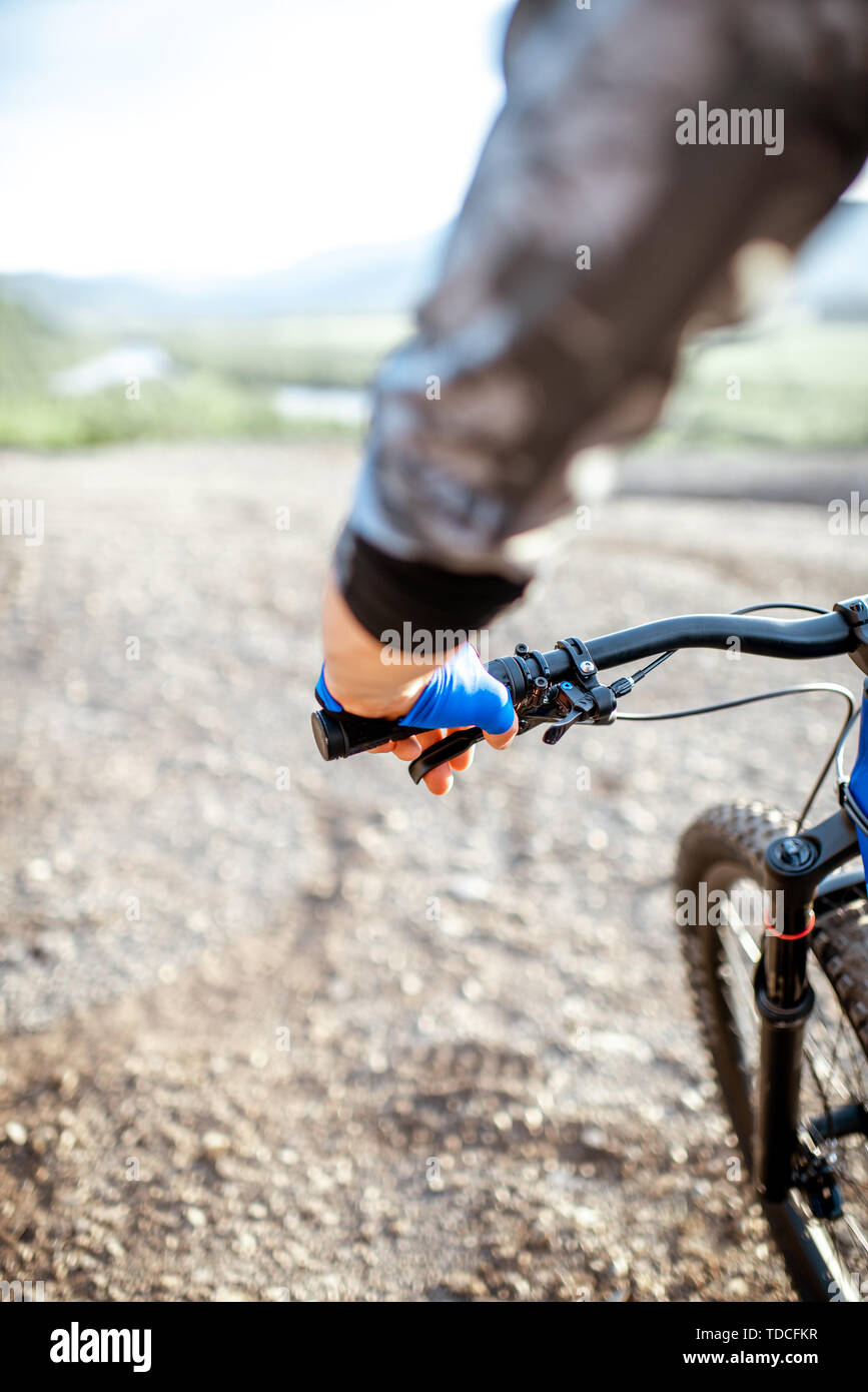 Mann reiten Fahrrad auf die felsigen Berge Blick auf die Hände und Helm Stockfoto