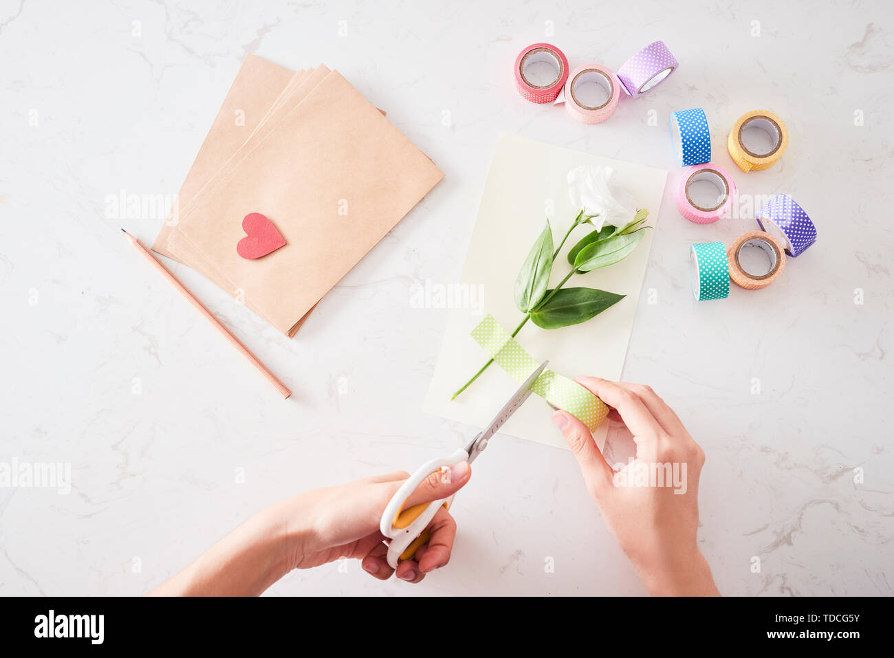 Die Dekorationen oder Grußkarte. Papierstreifen, Blume, Schere. Kunsthandwerk im Urlaub: Geburtstag, Muttertag oder Vatertag, 8. März, Hochzeit. Stockfoto