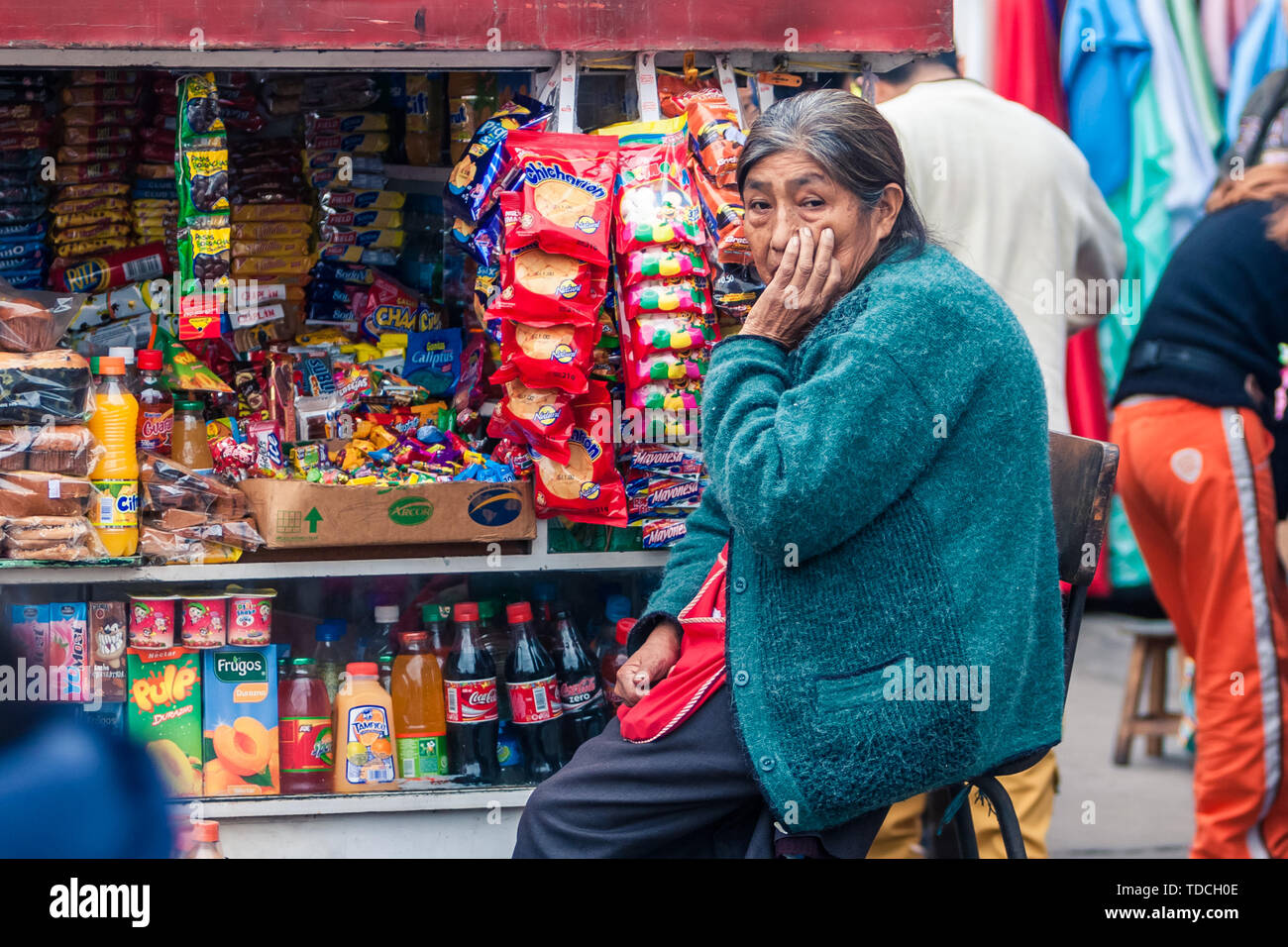 Lima/Peru Jun 13.2008: Alte indigene Frau Sitzbereich neben dem bunten Kiosk auf der Straße der größten Garment District genannt Gamarra. Stockfoto