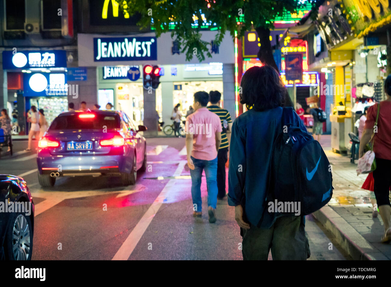 Die neun Fußgängerzone nach oben und unten Guangzhou unter der chinesischen Lampe von einsamen zurück, die Einsamen zurück von einem Wanderer bildet einen großen und starken Kontrast zur Umgebung. Stockfoto