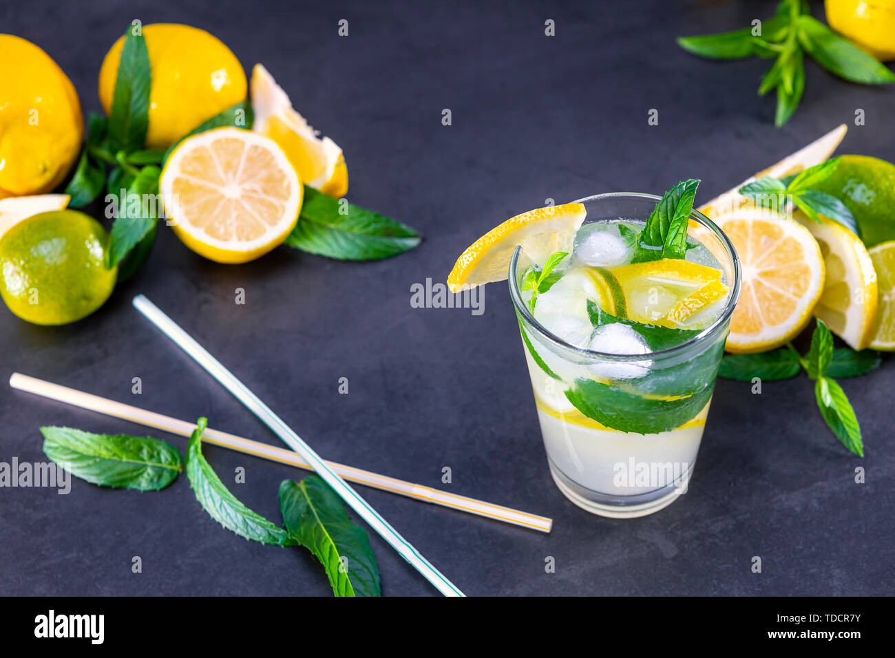 Blick von oben auf die frische Limonade mit Minze und Eis in Gläsern auf schwarzem Hintergrund. Fokus auf Eis. Stockfoto