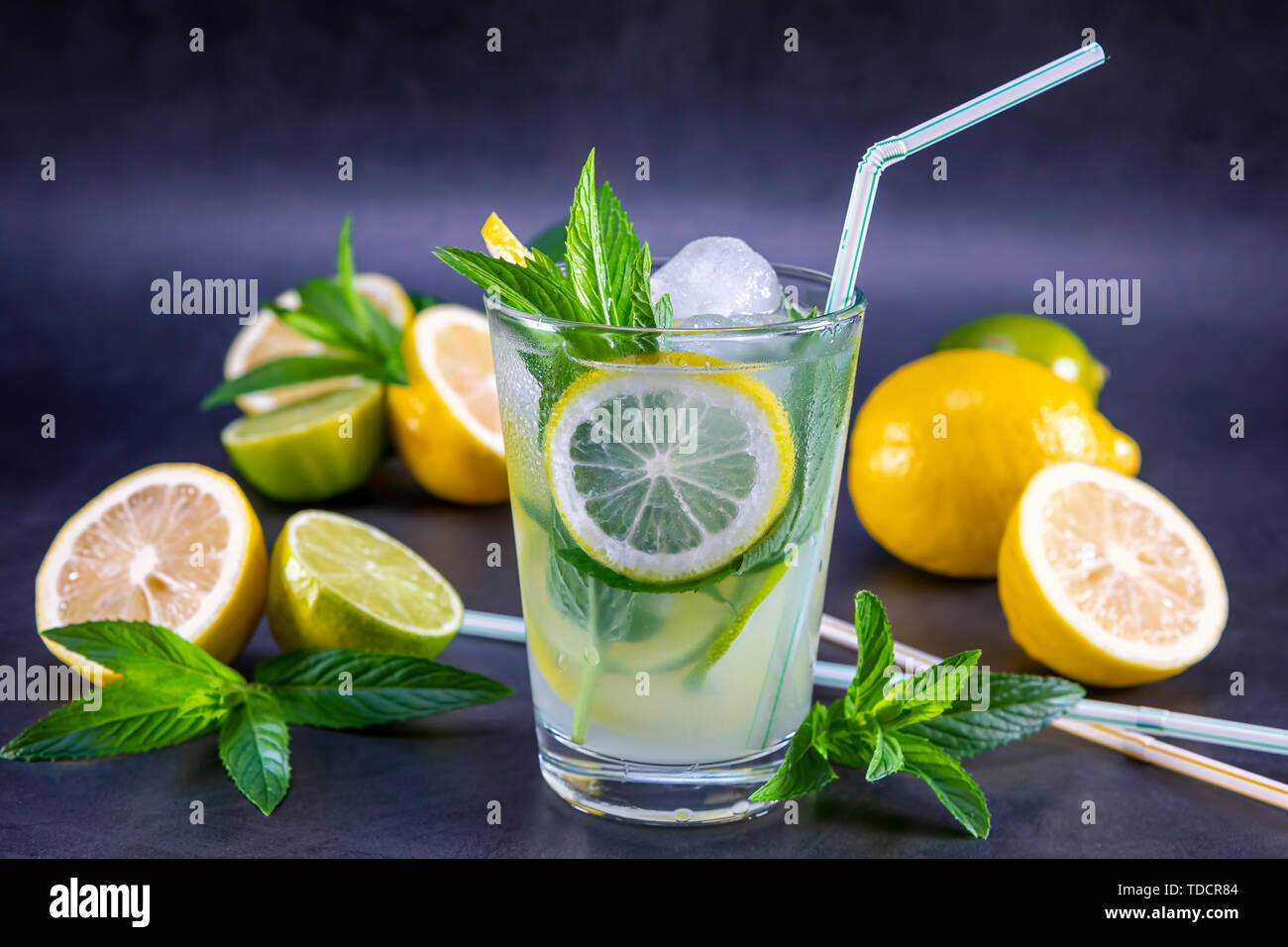 Kalt Erfrischende Sommer Limonade mit Minze im Glas auf einem grauen und schwarzen Hintergrund. Fokus auf Blatt und Eis im Glas. Stockfoto