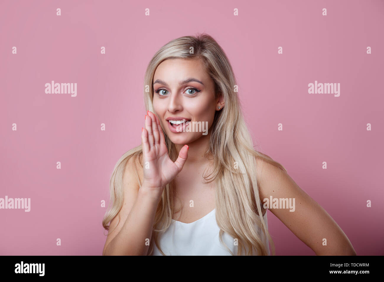 Gesprächig geheimnisvolle ziemlich schöne Frau mit blonden Haaren sagen geheimen heißen Bremsen Nachrichten und Kamera auf rosa Hintergrund Stockfoto